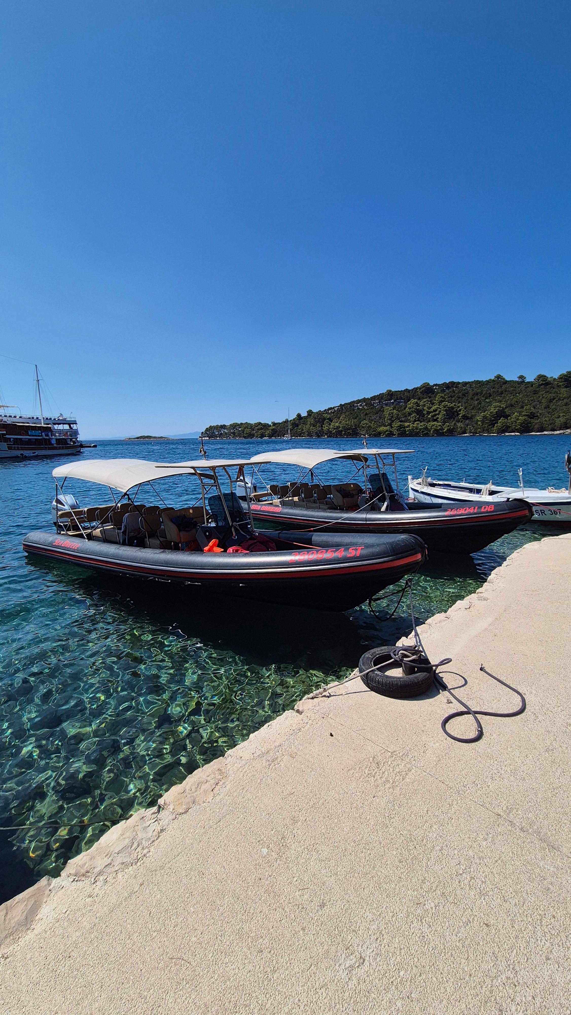 Two Dubrovnik Boat Excursion speedboats moored together at a Croatian island pier